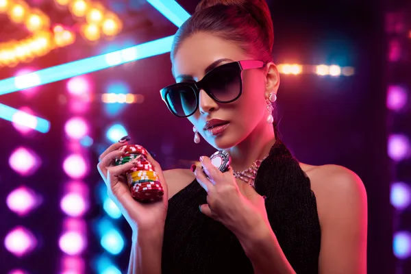 A young woman relaxing with her phone while dynamic casino elements float around her, illustrating the smooth mobile experience offered by the GGGJL app.