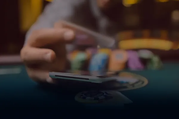 A person using their device against a moody casino-themed background, illustrating the smooth re-entry process at GGGJL.